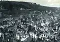 Depuis les hauteurs de Dinant, le quartier Saint-Pierre est en ruine, quelques rares édifices semblent avoir été épargnés.