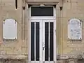 Les  plaques Société coopérative de reconstruction sur la mairie.