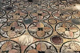 Un autre pavement moins bien conservé à Ostie. On y voit du marbre jaune antique, du blanc veiné, du porphyre vert (fines bordures), du porphyre rouge et du granite gris (quelques disques).