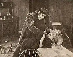 Affiche montrant la scène où le docteur se transforme en monstre sous le regard horrifié d'un autre homme.