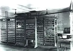 Photo en noir et blanc de plusieurs meubles remplis d'appareils électroniques.