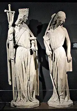 deux statues de femmes, l'une en reine couronnée, et l'autre aux cheveux dénoués et aux yeux couverts d'un bandeau