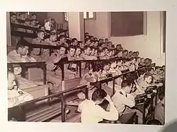 photo prise dans le grand amphithéâtre où l'on voit les jeunes médecins en uniforme assis sur les bancs attendant leur tour pour descendre à l'estrade choisir leur premier poste