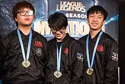 Trois joueurs en survêtements, médaille autour du cou.