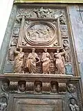 Porte d'église en bois, richement sculptée et ornée de nombreux personnages.
