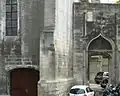 Porte au décor flamboyant et reste du mur de clôture.