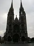 Une panne générale plonge la ville dans l'obscurité...Éd. Glénat 1986, p.&nbsp;8. Vu sur la sombre église Saint-Pierre et Paul à Ostende, employée par l'auteur pour démontrer la panne d'électricité. En 1999, une panne d'électricité plongea la ville dans le désarroi pendant deux heures.