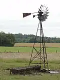 Paysage avec petite éolienne, pompe.