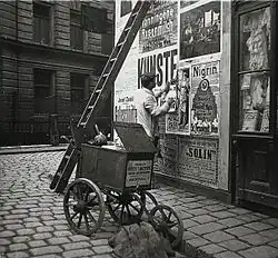 Colleur d’affiche dans une rue de Vienne en Autriche, photographié par Emil Mayer au début du XXe siècle.