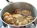 Vue d'intestins cuisant dans une casserole d'où s'élève une légère vapeur.