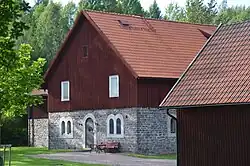 L'ancienne grange en bois et pierre de laitier qui accueille maintenant les archives.
