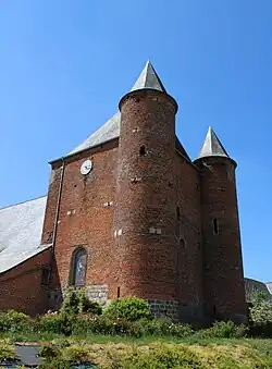 La haute nef fortifiée, surmontée d'une salle de refuge,  est flanquée de deux tours.