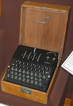 Photo d'un coffret en bois ouvert, contenant une machine à coder.