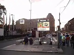 Une bouche du métro, la gare ferroviaire est à gauche.