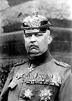 Portrait en noir et blanc d'un homme âgé en tenue militaire, il porte de nombreuses décorations sur son torse et un casque à pointe