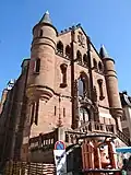 La façade construite au XIXe&nbsp;siècle par l'architecte Grinda à la place du chœur de l'église, avec des pièces du musée du Scaphandre devant.