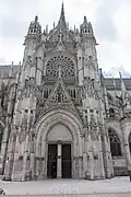 Nombreux soufflets dans la rose, les fenêtres, le gable du portail et en arcatures plaquées sur les murs, XVIe siècle.