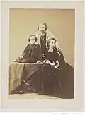 Félix Nadar, Félix Nadar, sa femme Ernestine et leur fils Paul, [Paul Nadar est assis sur une table, la main posée sur un livre], vers 1864.