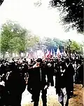 Photo en noir et blanc montrant des hommes marchant dans une rue