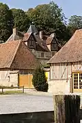 Une vue de la façade avant du manoir et de quelques dépendances.
