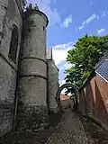 Allée piétonnière pavée qui passe sous l'arche de la tourelle.