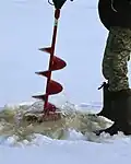 Une perceuse à glace en action.