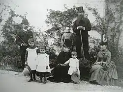 Famille posant avec parents et enfants, tous en tenue du XIXe&nbsp;siècle.