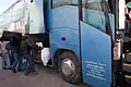  des africains chargent leur paquetage dans le coffre d'un bus