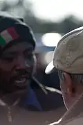 Portrait d'un africain de face et de son employeur italien (de dos).