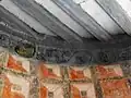 Une peinture murale et le décor d'une poutre.