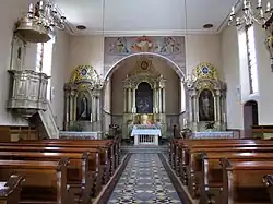 Vue intérieure de la nef vers la chaire et le chœur.