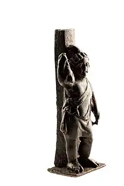 Statuette en bronze d'Attis avec ses attributs : lièvre[Où&nbsp;?] et bâton de berger ; A.D.[Quoi&nbsp;?] 75-150, trouvée à Tongres (Belgique), musée gallo-romain de cette ville.
