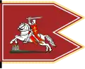Drapeau rouge sombre portant un chevalier blanc muni d'une épée blanche et d'un écu rouge et or, monté sur un cheval blanc caparaçonné de rouge, cabré au-dessus d'un château miniature.