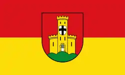 Blason en rouge et jaune avec un écu blanc orné d'une croix noire au milieu.