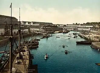 Le port et l'arsenal en Penfeld vus depuis le Grand Pont : de gauche à droite, côté Recouvrance, la caserne du 2e&nbsp;dépôt des équipages de la flotte (dit la Cayenne), les ateliers du plateau des Capucins ; côté Brest même, en arrière-plan la corderie et le bagne la surplombant, et à droite, la majorité générale.