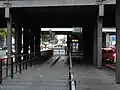Sous le pont de la gare avec accès ascenseur.