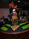 Le danseur tournoie en présentant des figures, à l'aide de tambourins ou d'autres accessoires