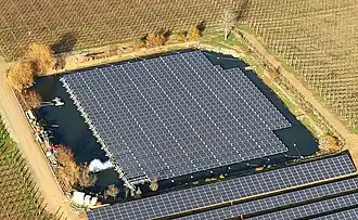 Photographie aérienne d'un plan d'eau sur lequel des panneaux solaires ont été installés.