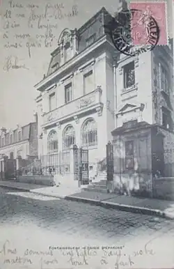 Façade principale vue latéralement depuis la rue, au tournant du XXe siècle.
