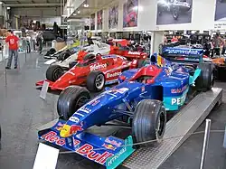 Voitures de Formule 1 exposées au musée, avec, au premier plan, la Sauber Petronas C18 de Jean Alesi en 1999.