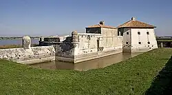 Côté sud-ouest, la structure à droite de la guérite en pierre, au milieu du rempart, au-dessus du fossé, "les latrines"