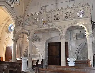 Le balcon intérieur en pierre sculptée.