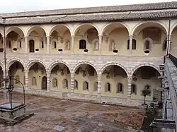 Cloître de Sixte IV avec, sur les deux ordres, les fenêtres romanes de l'ancien édifice (XIIIe&nbsp;siècle) et ce qui reste des fresques du XVIe&nbsp;siècle de Dono Doni et de son fils Lorenzo.