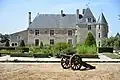 Photo en couleur d'un château avec un canon au premier plan.