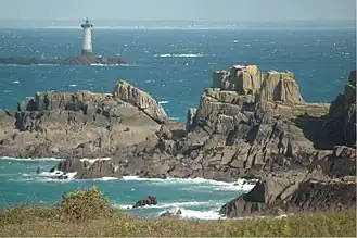 Rochers de la pointe du Grouin (leucogranite schistosé, en position très redressée) avec Granville en arrière-plan.