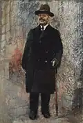 Portrait d'un homme debout dans un manteau noir et un chapeau.