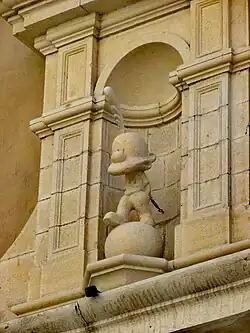 Fronton d'un bâtiment en pierre claire, orné d'une statue de Titeuf.