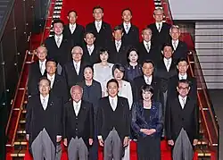 Photo de groupe d'hommes et de femmes installés sur un escalier.