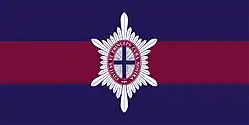 Un drapeau composé de trois bandes horizontales, la bande du centre rouge et les deux autres bandes bleues, et d'un insigne militaire au centre