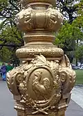 Détail d'un lampadaire de la place comportant le coq gaulois, symbole national de la France.